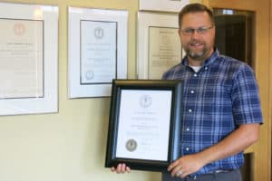 Greg Balfoort holding his OAAAS-Technology program diploma.